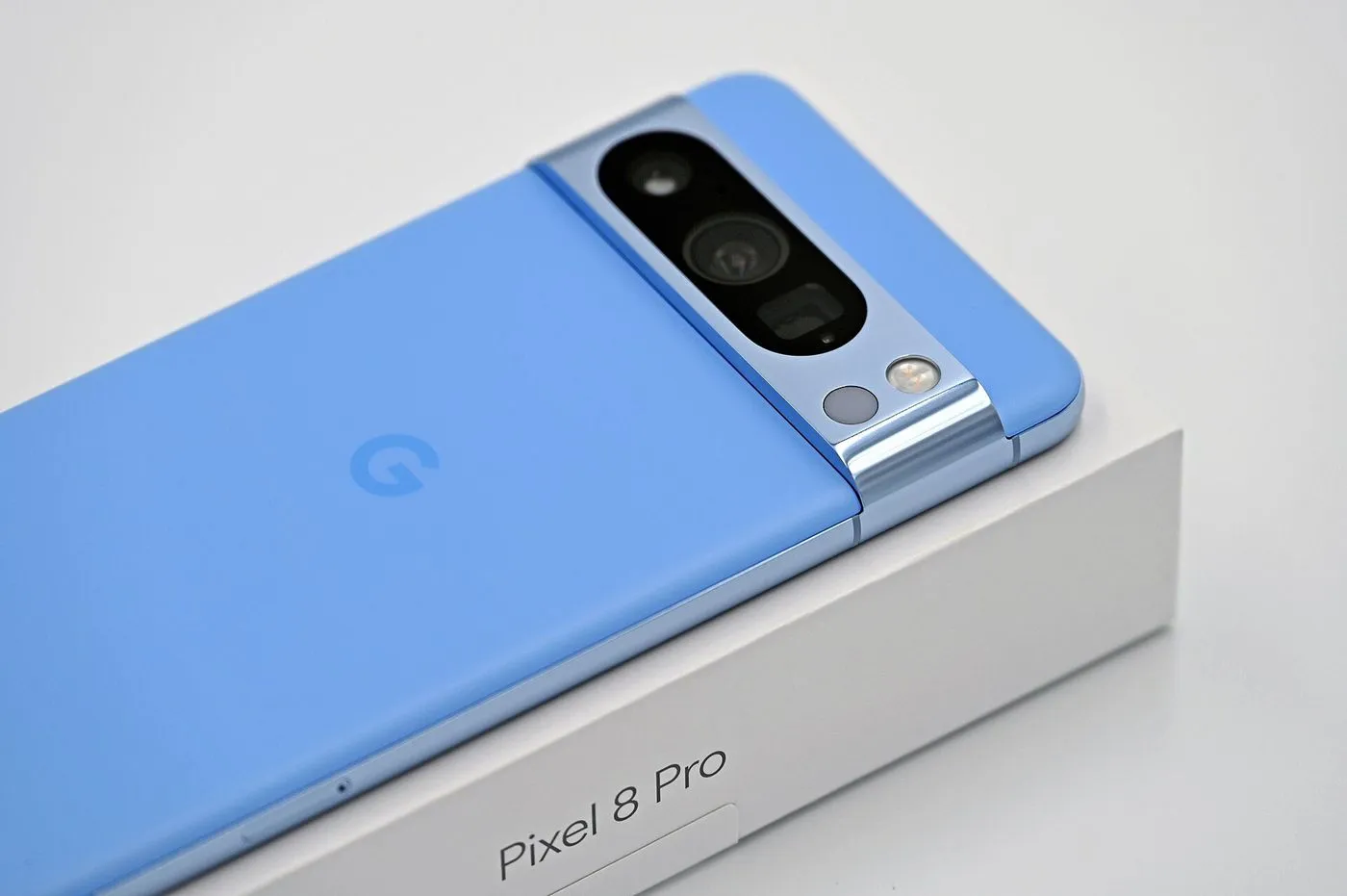 Un Google Pixel 8 Pro bleu posé sur sa boîte.